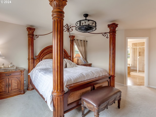 bedroom featuring ensuite bathroom, multiple windows, and light carpet