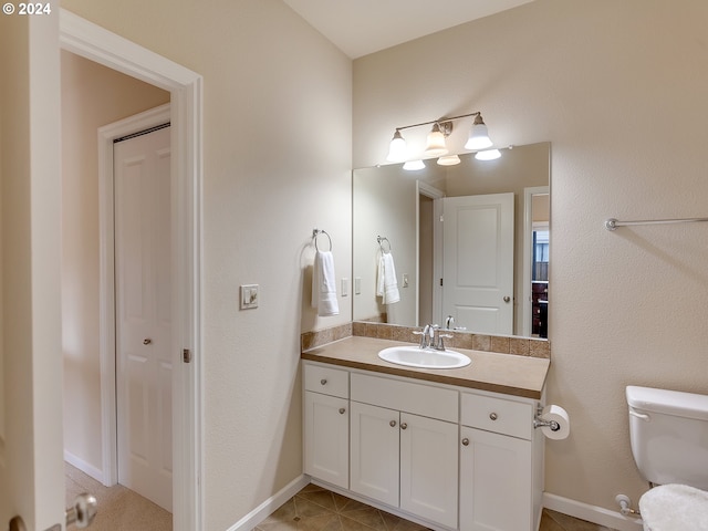 bathroom featuring tile patterned floors, toilet, and vanity