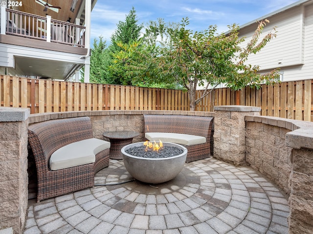 view of patio featuring a fire pit and a balcony