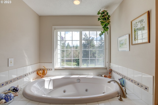 bathroom with a wealth of natural light, a relaxing tiled tub, and a textured ceiling