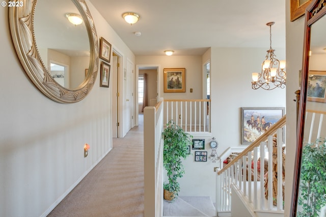 hall featuring carpet and a notable chandelier