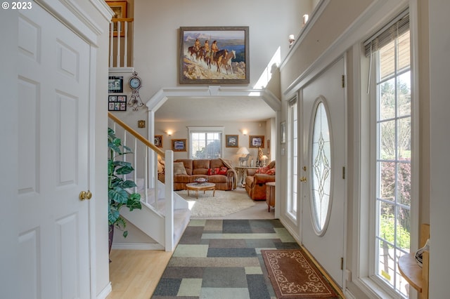 foyer featuring light wood-type flooring and a towering ceiling