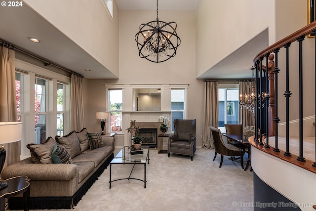 living room featuring a high ceiling, light colored carpet, and a chandelier