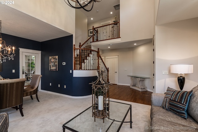 carpeted living room featuring an inviting chandelier and a high ceiling