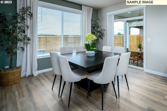 dining area with a wealth of natural light and hardwood / wood-style floors