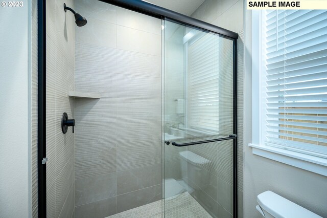 bathroom with a tile shower and vanity