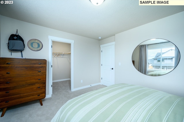 bedroom with light colored carpet, a spacious closet, and a closet