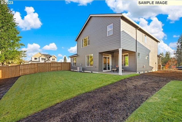 back of property with a lawn, central air condition unit, and a patio