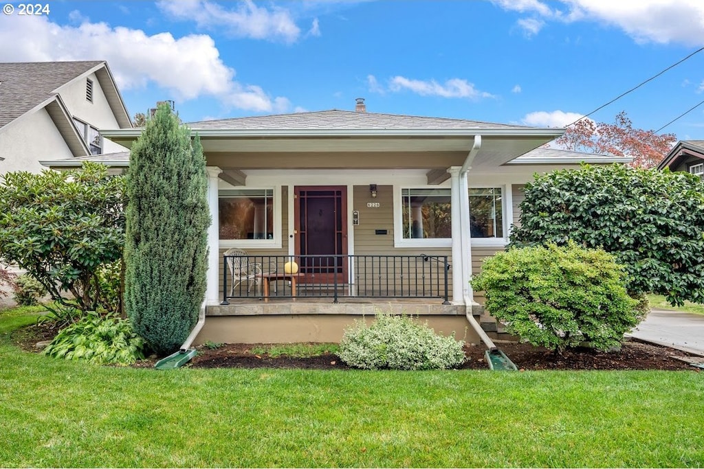 view of front of property with covered porch and a front lawn