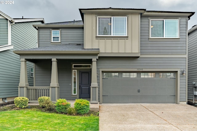 view of front of home featuring board and batten siding, covered porch, driveway, and an attached garage