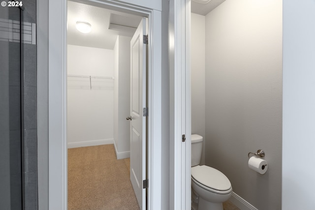 bathroom featuring baseboards, a spacious closet, and toilet