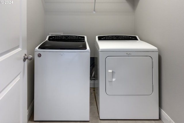 laundry area with light tile patterned flooring and independent washer and dryer