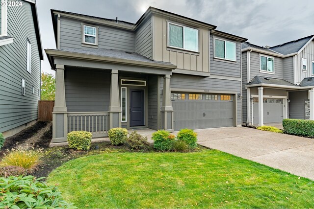 view of front of property featuring covered porch, board and batten siding, a front yard, a garage, and driveway