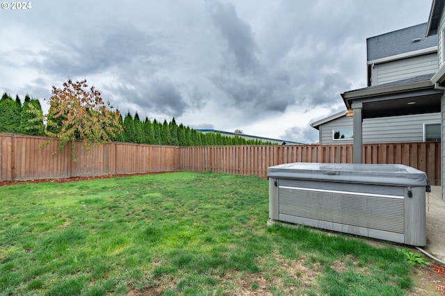 view of yard with a fenced backyard and a hot tub