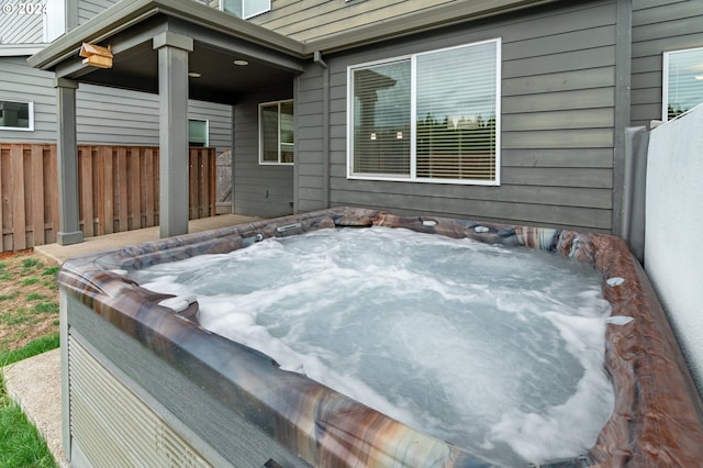 view of patio / terrace featuring a hot tub and fence