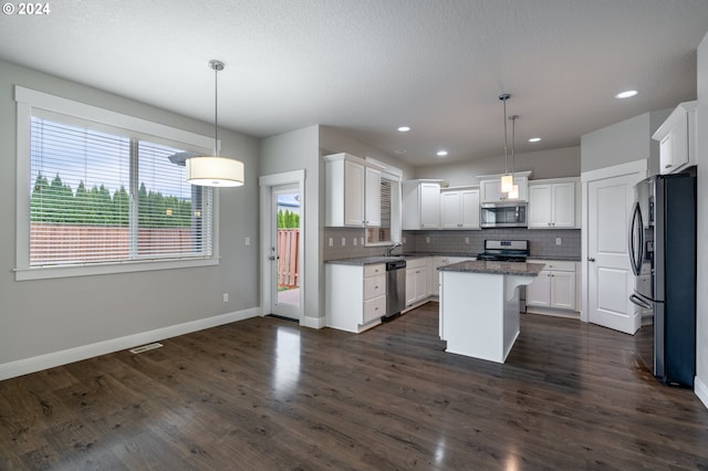 kitchen featuring appliances with stainless steel finishes, dark wood finished floors, and backsplash