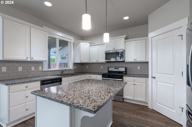 kitchen featuring dark hardwood / wood-style floors, appliances with stainless steel finishes, decorative light fixtures, a kitchen island, and white cabinetry