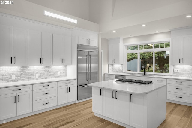 kitchen featuring sink, a kitchen island, white cabinetry, and appliances with stainless steel finishes