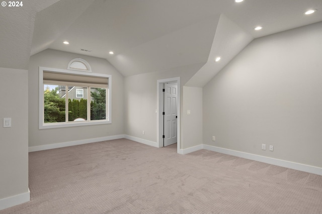 bonus room with light carpet and lofted ceiling