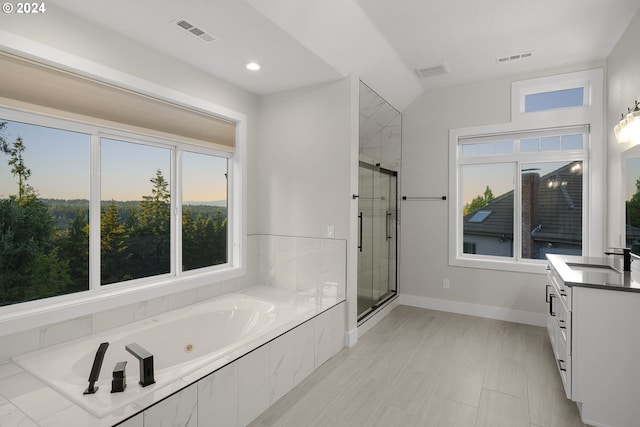 bathroom with vanity and shower with separate bathtub