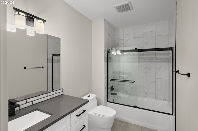 full bathroom with shower / bath combination with glass door, toilet, and vanity