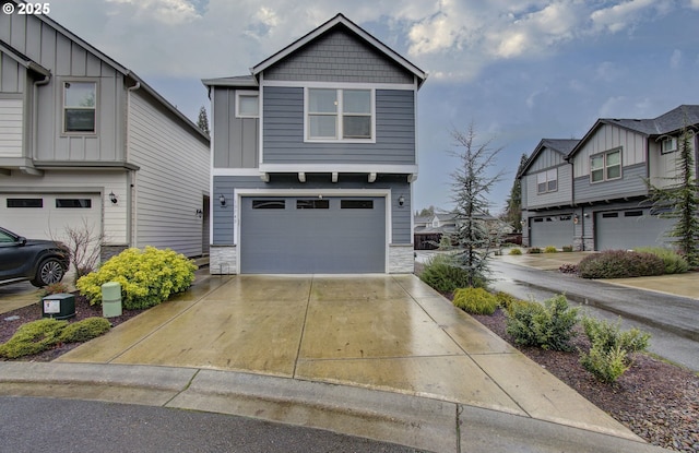 craftsman-style home featuring stone siding, a garage, board and batten siding, and concrete driveway