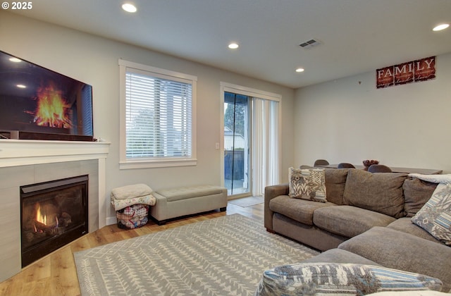 living room with a fireplace and light wood-type flooring