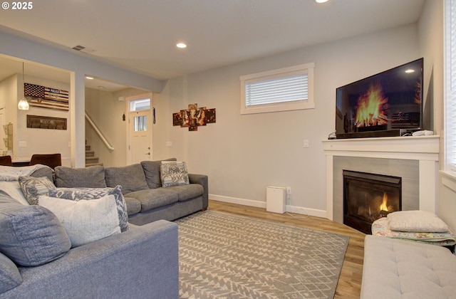living room with baseboards, stairs, a fireplace, wood finished floors, and recessed lighting
