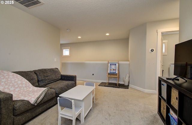 living room featuring carpet, a textured ceiling, baseboards, visible vents, and recessed lighting