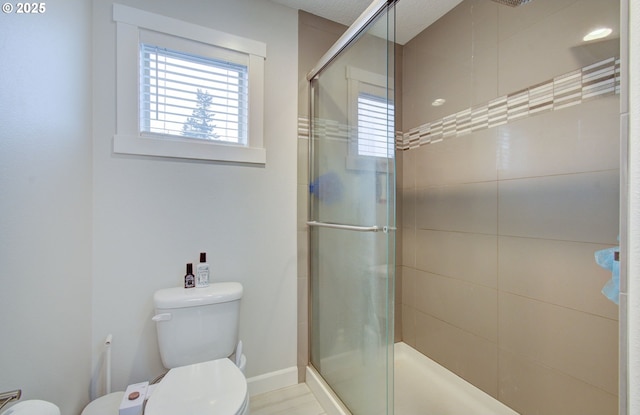 bathroom with toilet, a wealth of natural light, and a shower with shower door