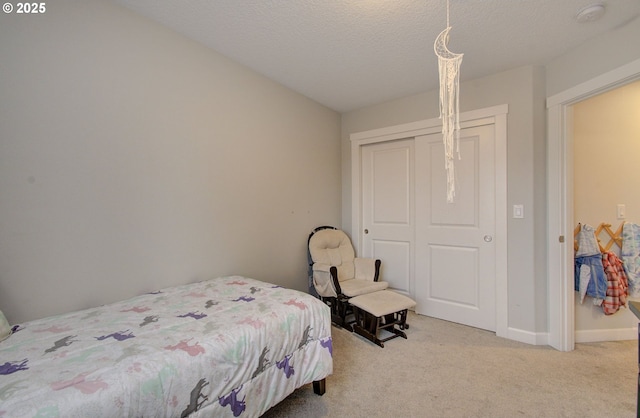 bedroom featuring a closet, light colored carpet, and a textured ceiling