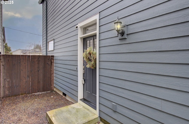 view of exterior entry featuring fence