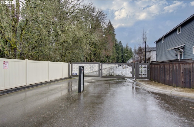 view of street with sidewalks, street lights, a gate, and curbs