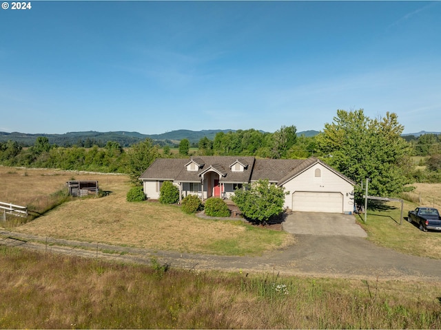 ranch-style house featuring a garage, a mountain view, and a front lawn