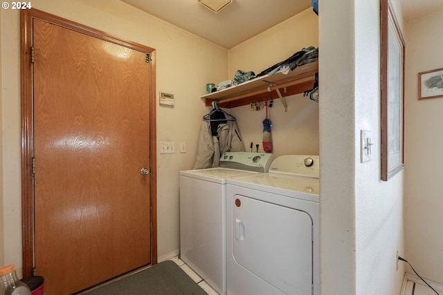 clothes washing area featuring light tile patterned flooring and washer and dryer