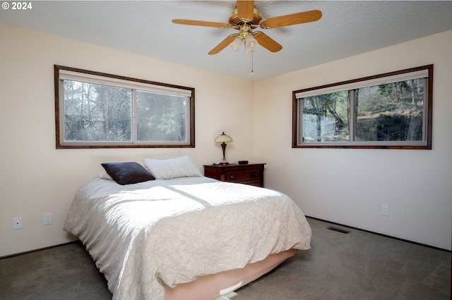 carpeted bedroom featuring ceiling fan and multiple windows