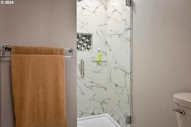 bathroom featuring an enclosed shower and toilet