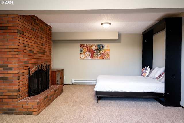 bedroom with a textured ceiling, carpet floors, a brick fireplace, and a baseboard heating unit