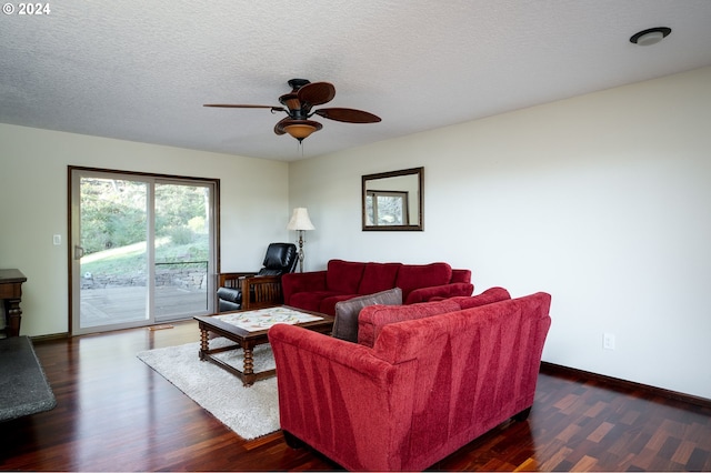 living room with ceiling fan, dark wood-type flooring, and a textured ceiling