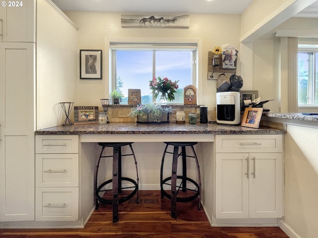 kitchen featuring dark hardwood / wood-style flooring and white cabinetry