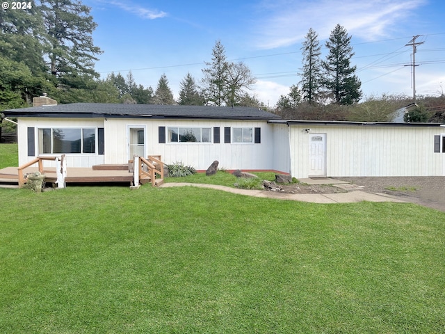 back of house featuring a wooden deck and a yard