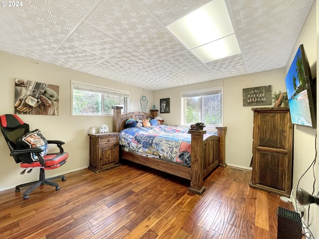 bedroom with hardwood / wood-style floors and multiple windows