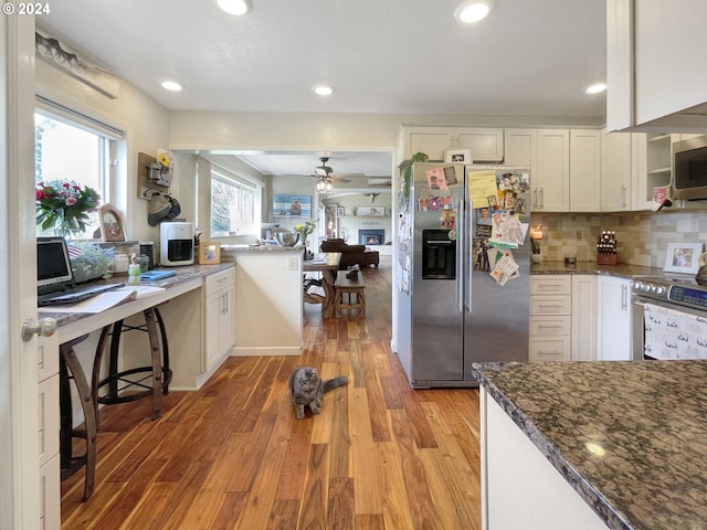 kitchen with stainless steel appliances, white cabinetry, and light hardwood / wood-style floors