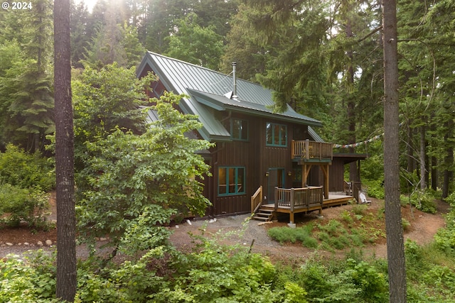 rear view of property with a balcony and a deck