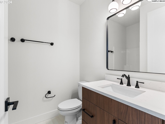 bathroom featuring tile patterned flooring, vanity, toilet, and a shower