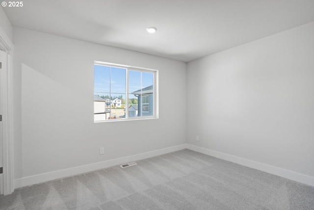 empty room with baseboards, carpet flooring, and visible vents