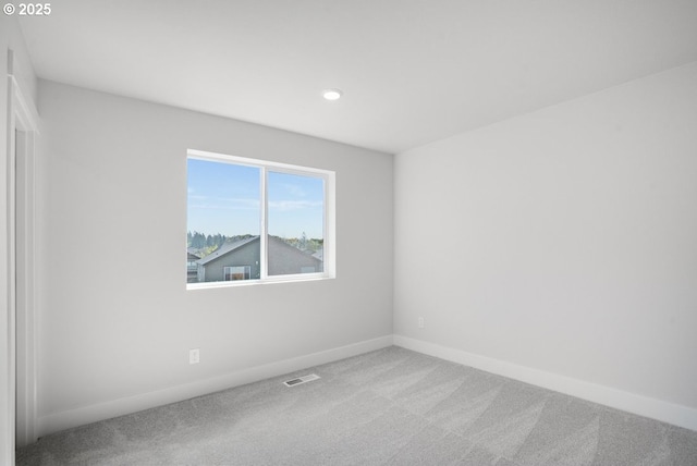 carpeted empty room featuring baseboards, visible vents, and recessed lighting