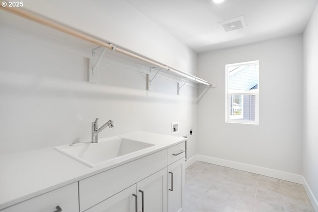 clothes washing area with hookup for a washing machine, a sink, electric dryer hookup, cabinet space, and baseboards