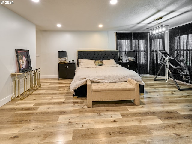 bedroom featuring light hardwood / wood-style flooring and a textured ceiling