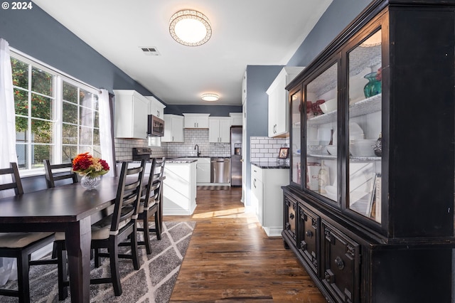 dining space featuring sink and dark wood-type flooring